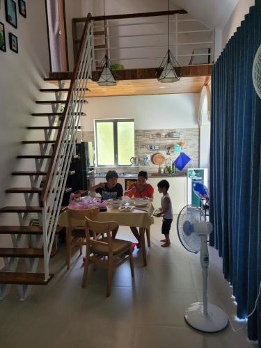 a group of people sitting at a table in a kitchen at Summer Pool 2 Bedrooms Villa in Phu Quoc