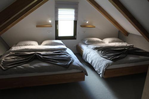 2 camas individuales en una habitación con ventana en Apartment Bajta - Rogla en Zreče
