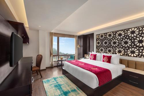 a hotel room with a bed and a television at Ramada by Wyndham Gangtok Hotel & Casino Golden in Gangtok