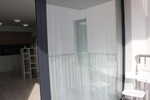 a sliding glass door with white blinds in a kitchen at LEO Apartment FREE PARKING!!! in Bratislava