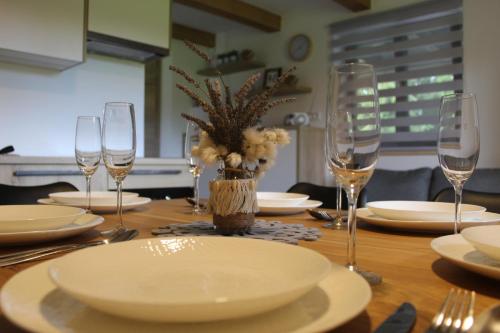 una mesa de madera con platos y vasos. en Apartment Bajta - Rogla en Zreče