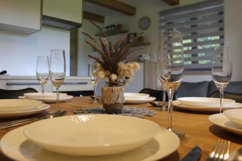 a wooden table with plates and glasses on it at Apartment Bajta - Rogla in Zreče