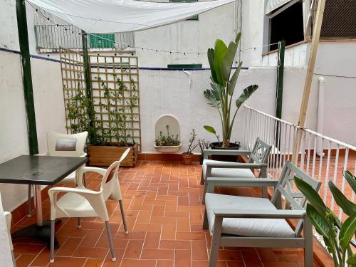 a patio with chairs and a table and a table and chairs at Madison Rooms in Sitges