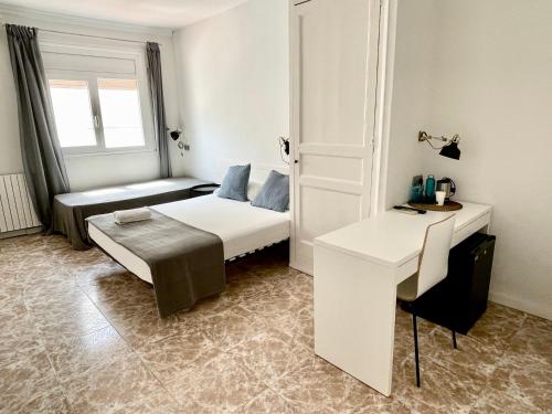 a small room with a bed and a desk at Madison Rooms in Sitges