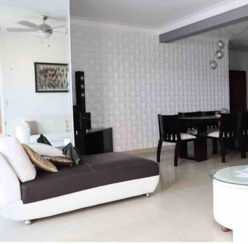 a bedroom with a bed and a table and a piano at Self check in , moderno, A/C completo Wifi, TV 4K in Santiago de los Caballeros