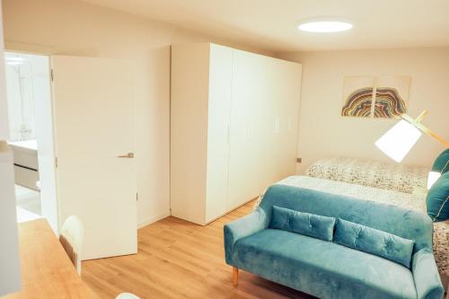 a bedroom with a blue chair and a bed at RIACENTRUM - Smart Residence in Aveiro