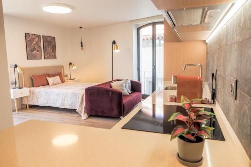 a bedroom with a bed and a couch in a room at RIACENTRUM - Smart Residence in Aveiro