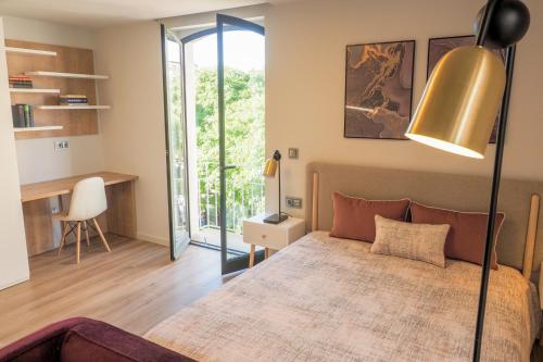 a bedroom with a bed and a desk with a chair at RIACENTRUM - Smart Residence in Aveiro