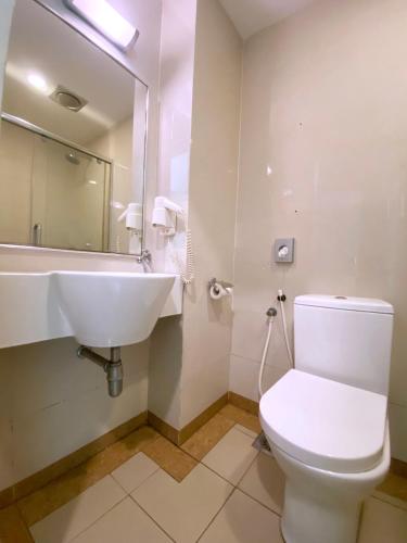 a bathroom with a white toilet and a sink at D'concept Hotel Kulim in Kulim
