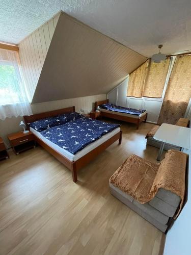 ein großes Schlafzimmer mit 2 Betten und einem Sofa in der Unterkunft Chaty Podhradi nad Dyji in Podhradí nad Dyjí