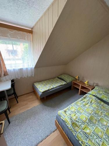 Zimmer mit 2 Betten, einem Schreibtisch und einem Fenster in der Unterkunft Chaty Podhradi nad Dyji in Podhradí nad Dyjí