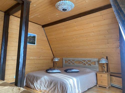 a bedroom with a bed in a log cabin at Vilni Vitry in Osmoloda