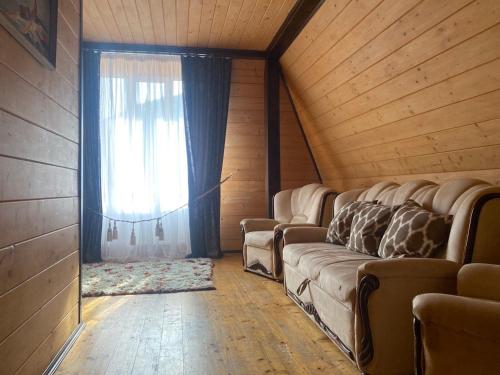 a living room with a couch and a window at Vilni Vitry in Osmoloda