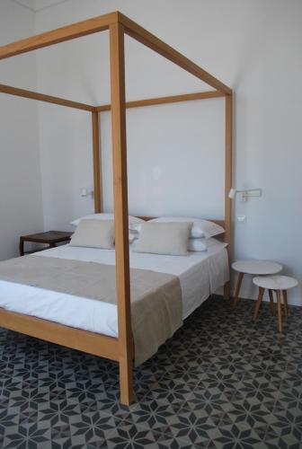 una camera con letto a baldacchino in legno di Palazzo Del Cavaliere a Gallipoli