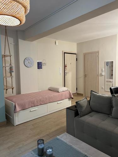 uma sala de estar com uma cama e um sofá em Vicky’s studio em Piraeus