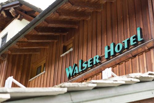 a sign on the side of a wooden building at Hotel Walser Courmayeur in Courmayeur
