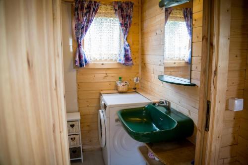 y baño con lavabo verde y lavadora. en Magia Krutyni, en Krutyń