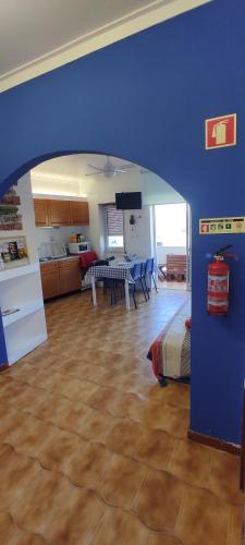 a room with a blue wall and a kitchen and a table at Ocean View Dive House in Sesimbra