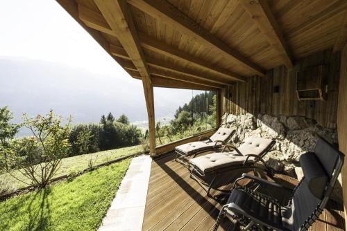 a porch of a wooden house with chairs on it at Haus Schwarzenberg in Stummerberg