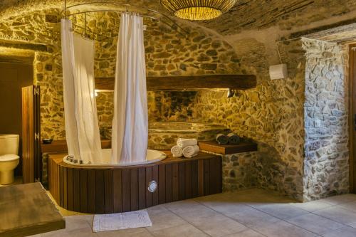 a bathroom with a tub with a shower curtain at Mas Renart in Mollet de Perelada