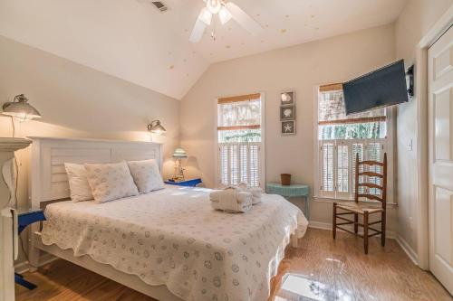 um quarto com uma cama com uma colcha branca e 2 janelas em 1200 London Ave Port Royal, SC 29935 em Port Royal