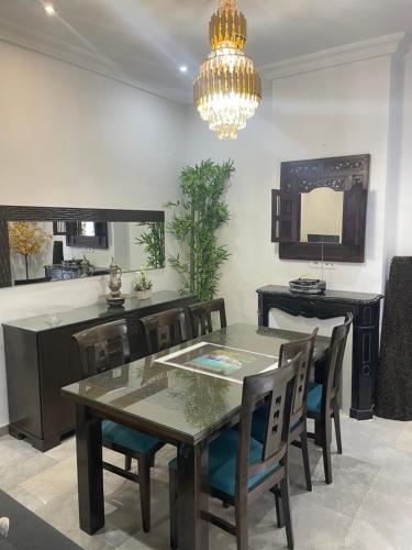 a dining room with a table and chairs and a chandelier at Appartemet haut standing in Tunis