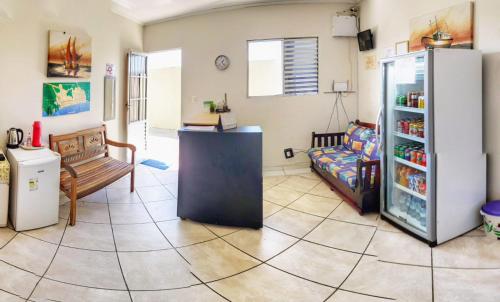 a living room with a refrigerator and a couch at Pousada Aconchego in Peruíbe