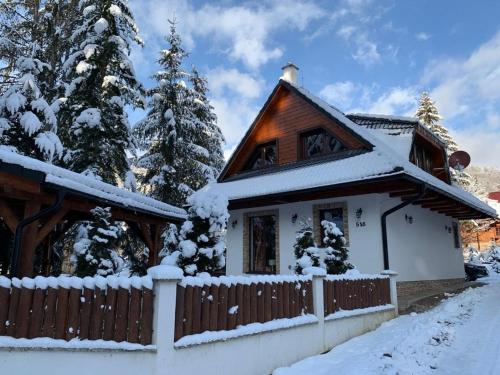 a house covered in snow with a fence at Chata Mlynná in Mýto pod Ďumbierom