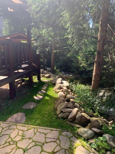 a garden with a bench and a rock path at Chata Mlynná in Mýto pod Ďumbierom