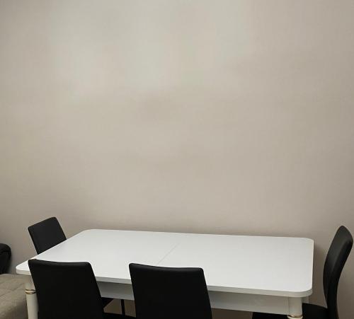 a white table and chairs against a wall at Coastal, 2-bedroom rental unit in Golem