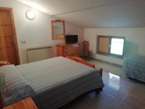 a bedroom with a bed and a dresser and a television at Grotta dei Colombi in Scanno