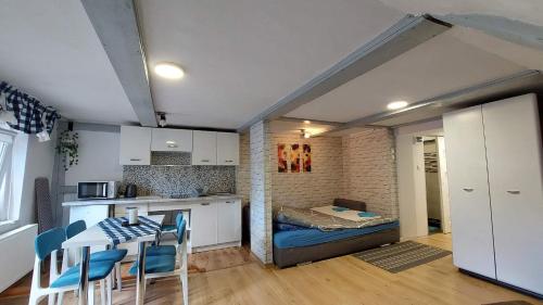 a room with a kitchen and a room with a bed at Słoneczny apartament in Duszniki Zdrój