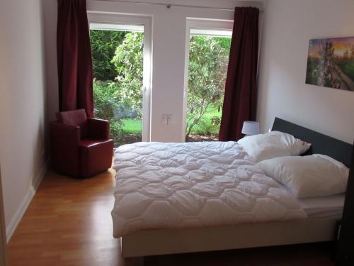 ein Schlafzimmer mit einem weißen Bett und einem Fenster in der Unterkunft Auszeit am Fähranleger in Grünendeich