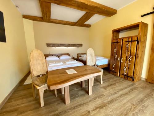 a room with a wooden table and two beds at Noclegi - Karczma Solina in Solina
