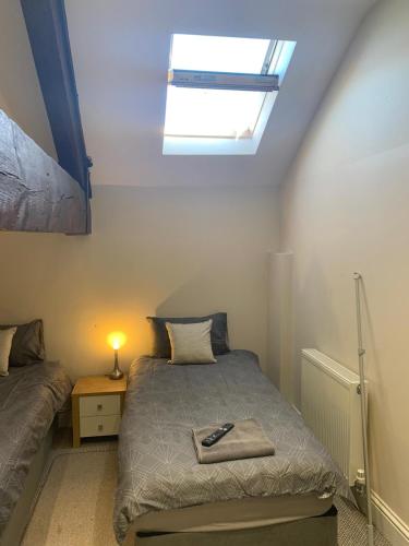 a small bedroom with a bed and a skylight at RIVERSIDE APARTMENT IN THE CENTRE in Boston