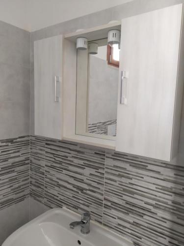 y baño con lavabo y espejo. en Casa Vacanze Lu Trappitu, en Magliano