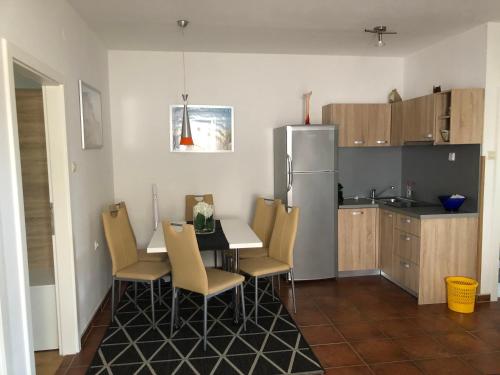 a kitchen with a table and chairs and a refrigerator at Appartements Antunovic in Povljana