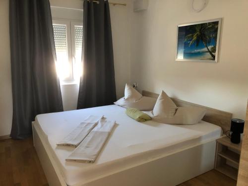 a white bed with two napkins on top of it at Appartements Antunovic in Povljana