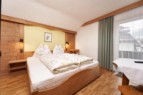 a bedroom with a bed and a large window at Aktivurlaub Morandell in Sölden