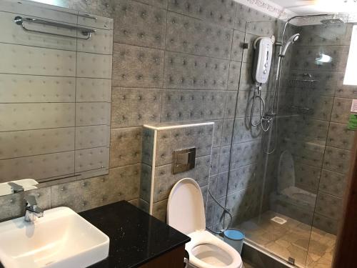 a bathroom with a shower and a toilet and a sink at Progressive Park Hotel in Nairobi