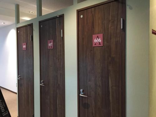 a row of wooden doors in a room at 1 Night 1980 Hostel Tokyo Asakusa Simple Stay in Tokyo
