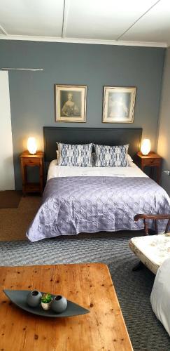 - une chambre avec un grand lit et une table en bois dans l'établissement The Sun Room, à Graaff-Reinet