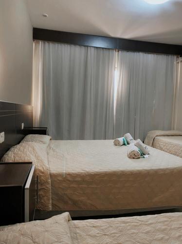 a bedroom with two beds and a window at Hotel Puesta del Sol in San Rafael