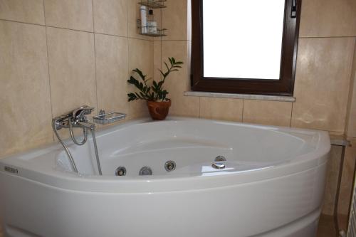 a white bath tub in a bathroom with a window at Villa Helidoni in Pondikianá