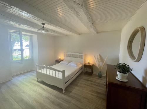 - une chambre avec un lit blanc et un miroir dans l'établissement Gîte de Pampe Lune & Spa, à Pampelonne