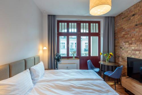 a bedroom with a white bed and a television at PROVENIR HOME KWIATOWA 5 in Poznań