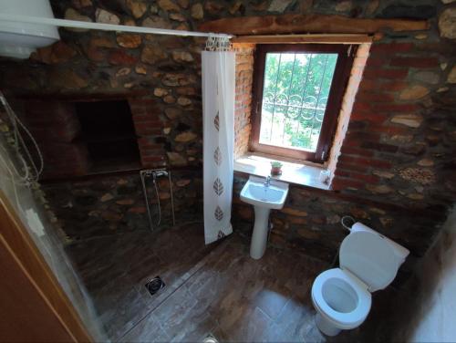 a stone bathroom with a toilet and a window at House of Poposka Kuka in Bitola