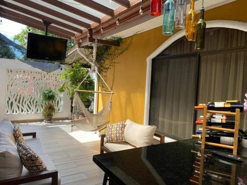 a screened in porch with a hammock and a patio at Airport SJO Residence - Edward & Familia Inn in Alajuela City