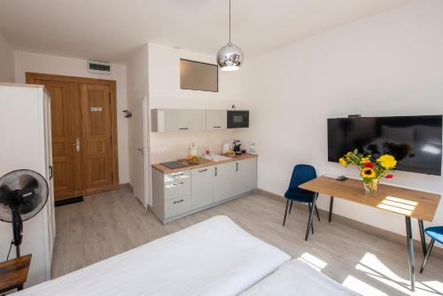 a kitchen and dining room with a table and a refrigerator at PROVENIR HOME KWIATOWA 5 in Poznań