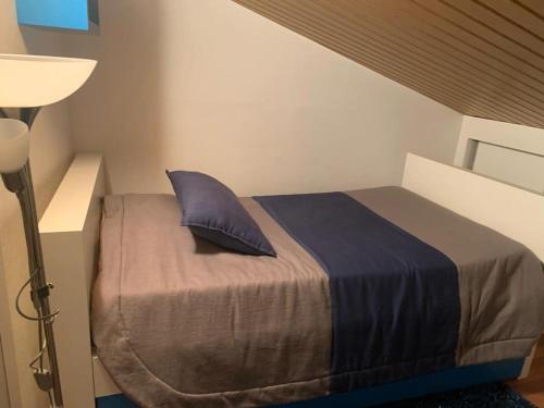 a bed with a blue pillow in a room at Casa da Gracita in Pereira